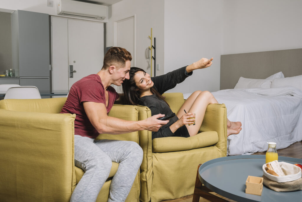young couple enjoying tv in their hotel room