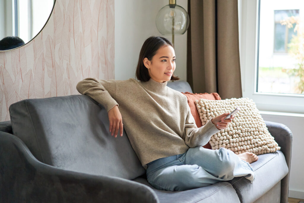 young woman enjoying TV in hotel room