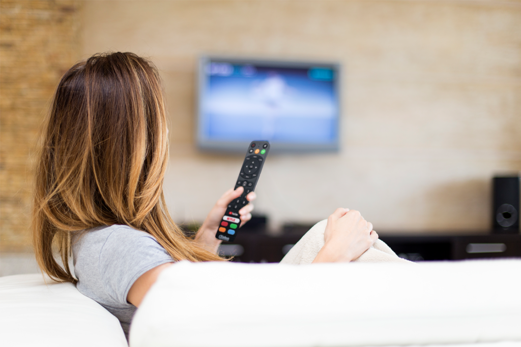 Frau hält eine Cast-Fernbedienung und schaut Chromecast für die Hotellerie