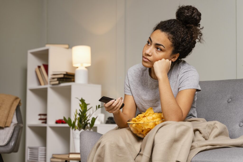 ケーブルテレビでチャンネルを変えながら退屈している女性