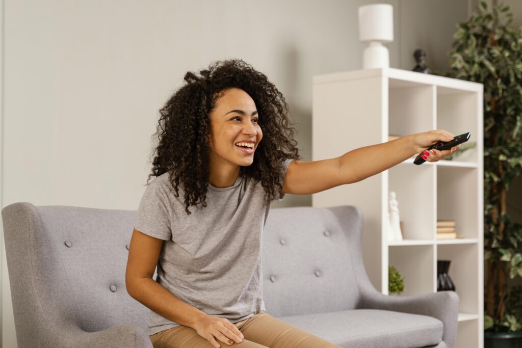 キャスティングシステムのあるホテルで楽しそうにテレビを見る女性